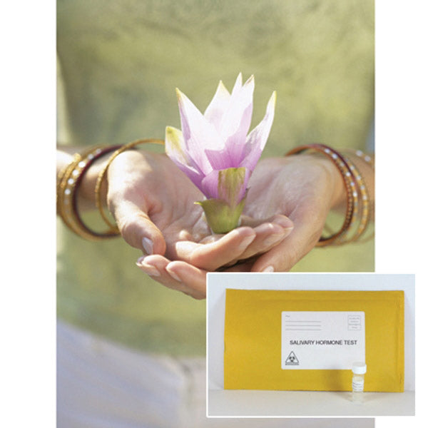 A woman wearing bracelets and holding a flower in the palm of her hands with a salivary hormone test in front of her.